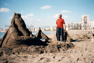 Am Strand von Aguilas, ein Künstler baut Skulpturen wie hier zu sehen einen Wassermann aus Sand, entstanden an der Calle del Aire wo auch der Yachthafen in dieser Bucht liegt.