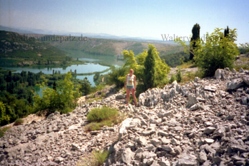 Touristin die vor einer eindrucksvollen Landschaft in Kroatien posiert, im Hintergrund einer der Nationalparks mit seiner Flusslandschaft.