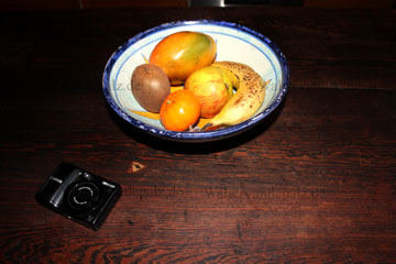 Der Fotoapparat der neben der Obstschale liegt den nehme ich weil der so schön klein ist, habe aber noch andere Kameras. Die Obstschale habe ich im Marokko Urlaub gekauft. In der Obstschale liegen ungeschält: eine reife Banane, ein reifer Bio-Apfel, eine reife Mango die rötlich und gelb schimmert nur noch wenig grün daran sowie eine reife Kiwi. Daraus zusammen mit Quark und etwas Müsli - ein leckeres und gesundes Frühstück wie man es bei den Indien Reisen gerne zu sich nimmt.